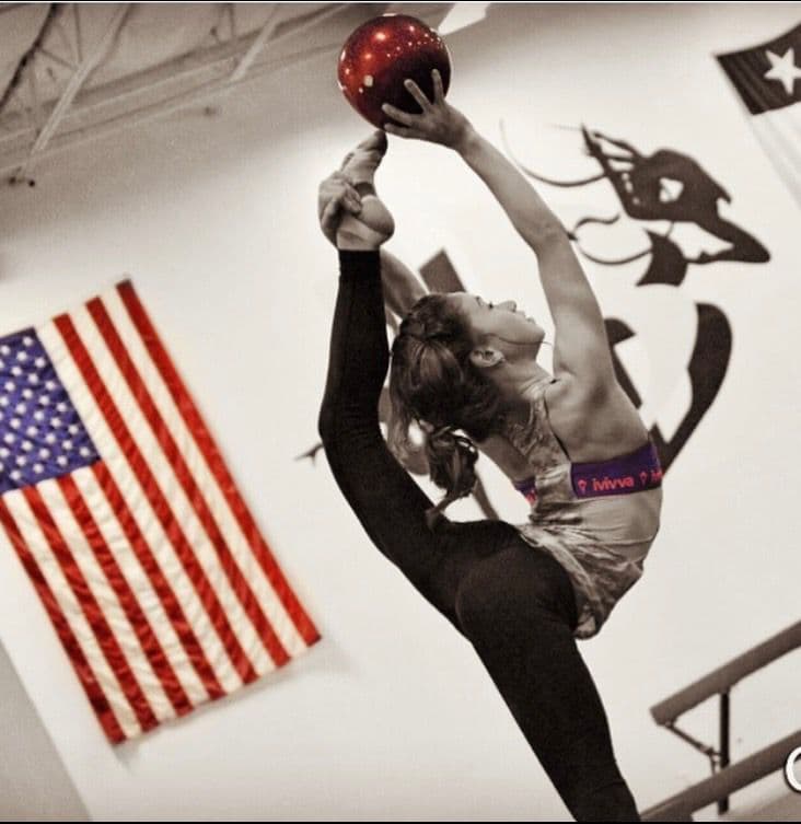 Gymnast performing backbend with ball