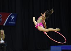 Gymnast leaping with hoop at competition