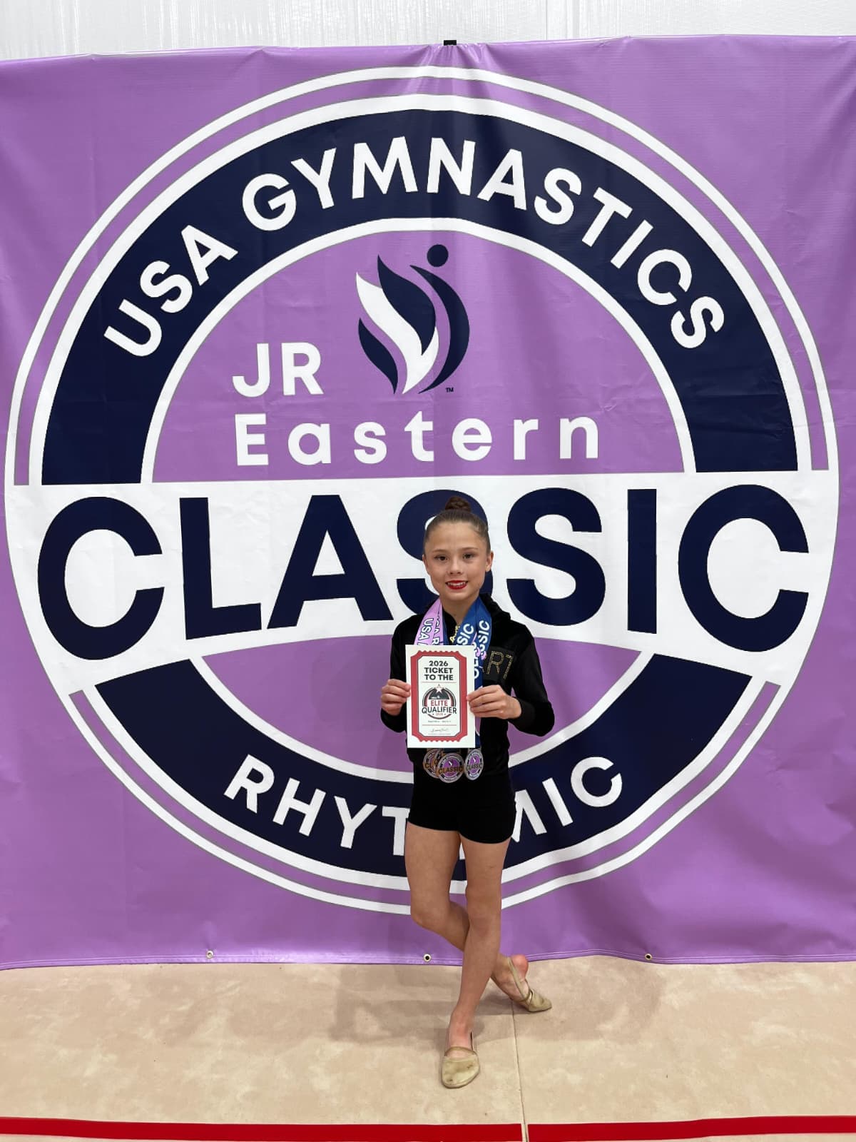 Young athlete with two medals and qualifier ticket at JR Eastern Classic