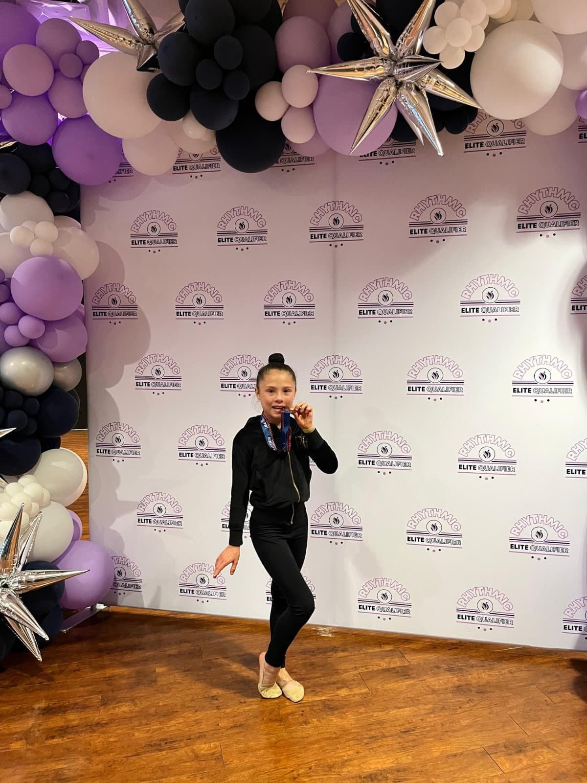 RRT athlete kissing her medal at the 2026 USAG Rhythmic Elite Qualifier