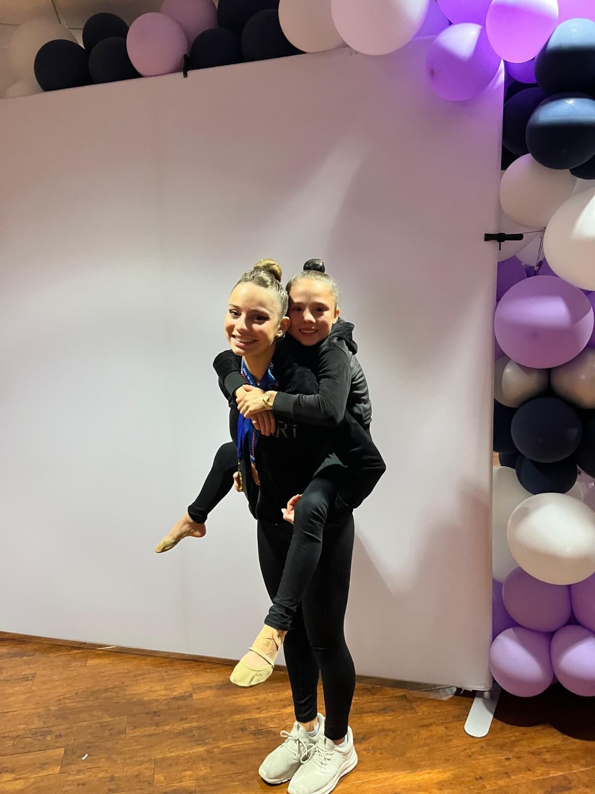 Two RRT medalist teammates celebrating with a piggyback hug at the 2026 USAG Rhythmic Elite Qualifier