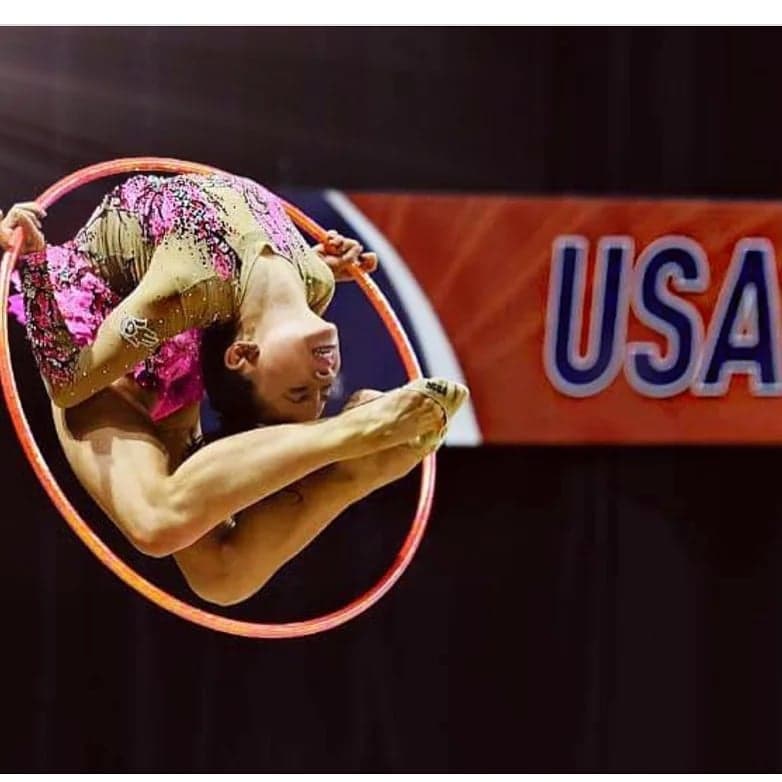 Gymnast performing aerial pass through hoop at USA Gymnastics Championships