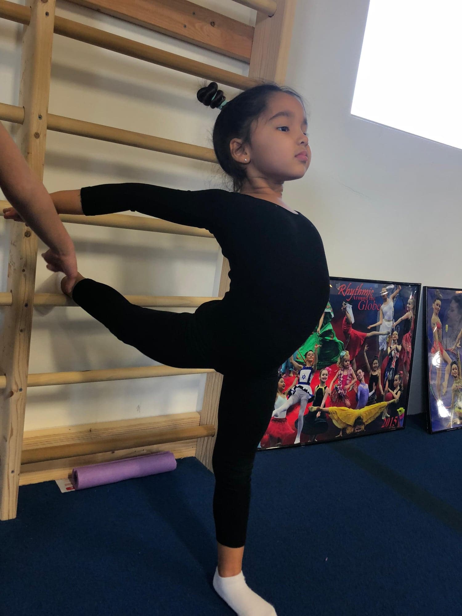 Young student practicing arabesque at barre