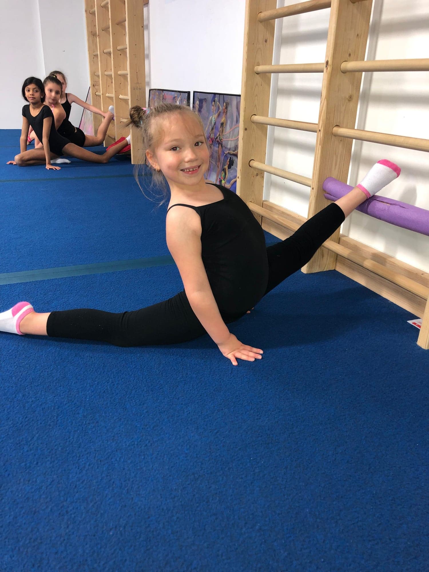Student practicing oversplits at barre